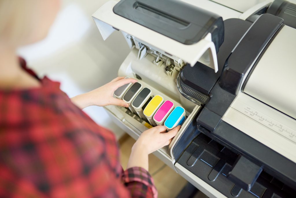 Woman looking at printer ink cartridges.