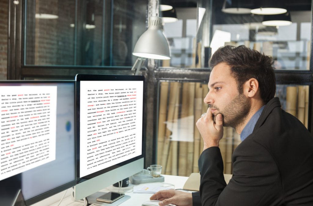 Man proofreading his document before printing to ensure he doesn't waste paper.