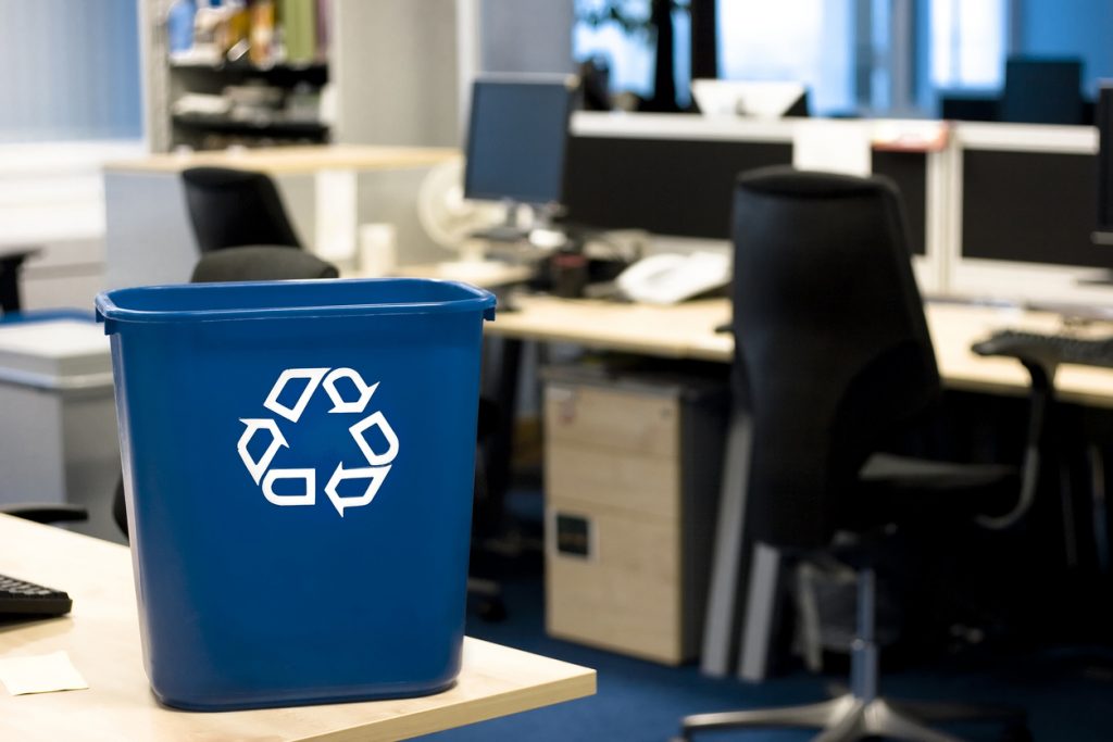 Blue recycling bin in the office helping to remind employees to recycle their paper.