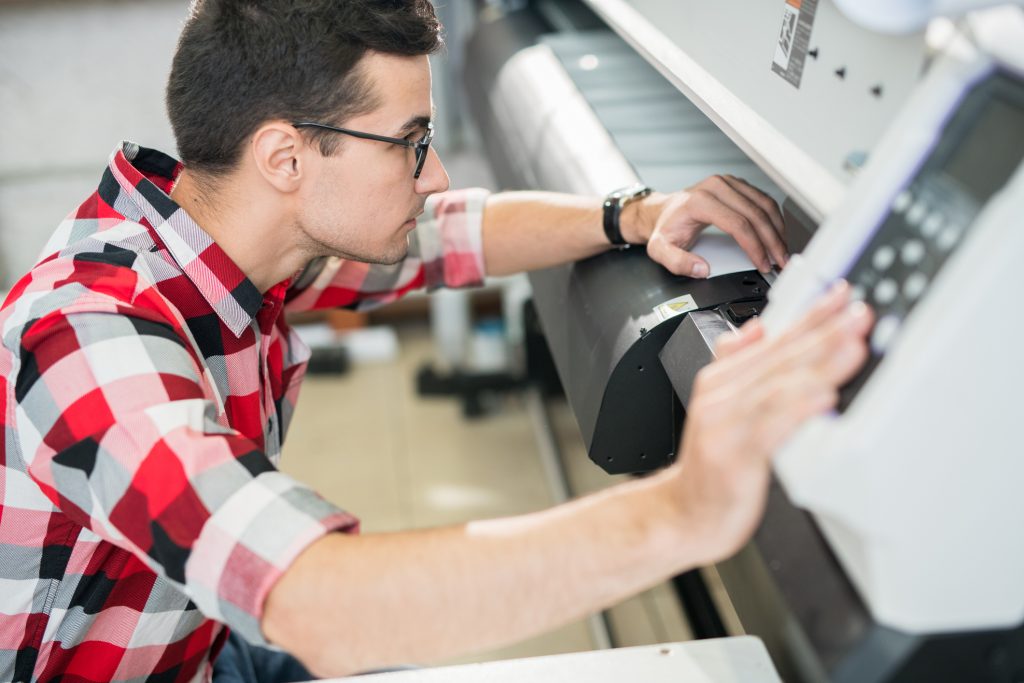 Man using a wide format printer.